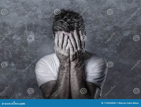 Portrait Of Sad And Depressed Man Covering Face With Hands Looking