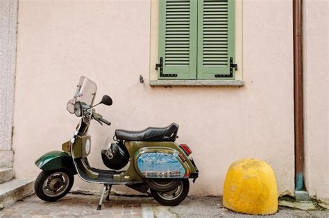 Premium Photo Motor Scooter Parked On Street Against Building