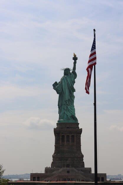 Premium Photo | Statue of liberty with american flag