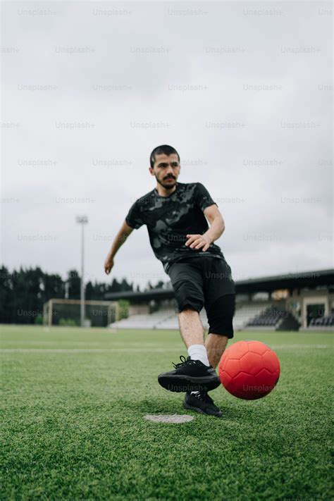 Una pelota de fútbol roja sentada encima de un campo de fútbol foto