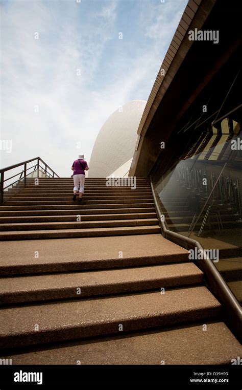 A man climbing the stone stairs outside The Sydney Opera House performing arts centre in Sydney ...