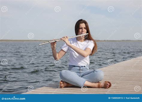 A Beautiful Woman Posing In Beach While Playing On A Flute Stock Image