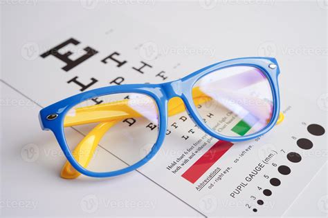Glasses on eye exam chart to test eyesight accuracy of reading