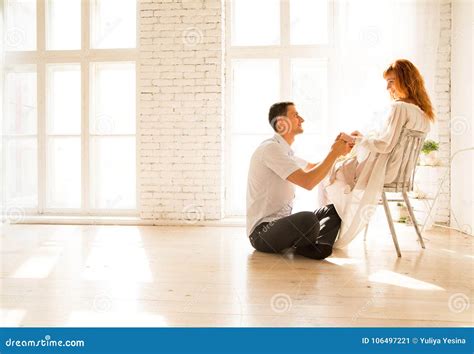 Husband Sitting On The Floor Pregnant Woman On A Chair The Husband