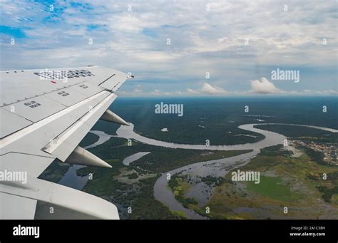 View From Airplane Window Wing Of An Airplane Flying Above The Clouds