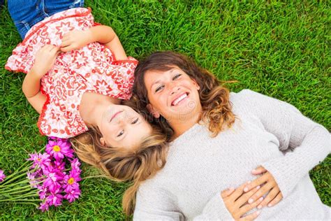 Mother And Daughter Lying Together Outside On Grass Stock Image Image