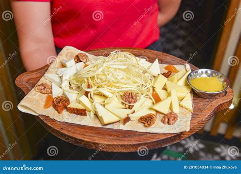 Assorted Cheeses In Various Shapes And Sizes Waiter Serving Cheese