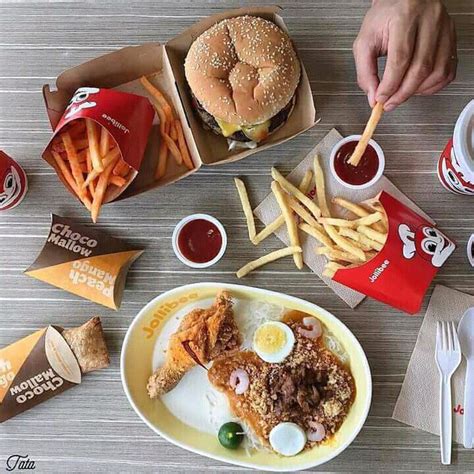 a table topped with plates of food and fries next to cups of ketchup