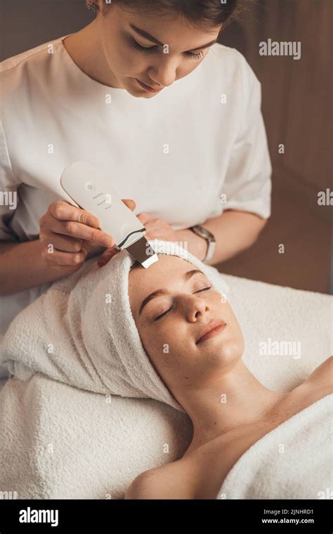 Cosmetologist With Ultrasonic Scrubber Working With Womans Face Skin