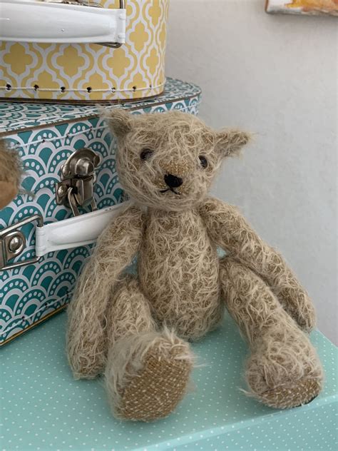 A Brown Teddy Bear Sitting On Top Of A Blue Table Next To Two Suitcases