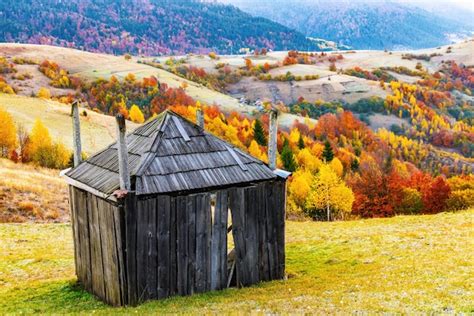 Mały drewniany dom ze stogu siana zbudowany na trawiastym zboczu w