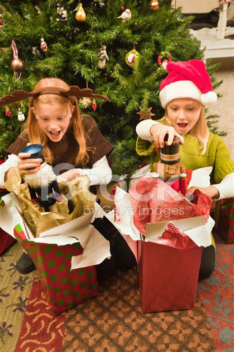 Happy Children Opening Presents In Front Of Christmas Tree Vt Stock ...