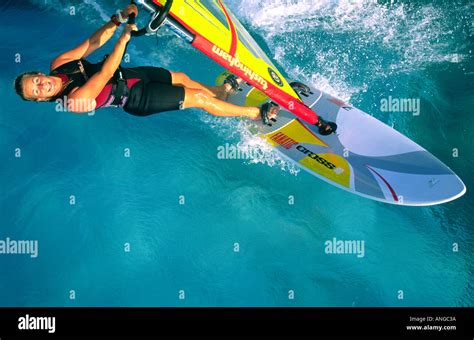 Aerial View Of Single Female Windsurfer Sailing On Crystal Clear Light