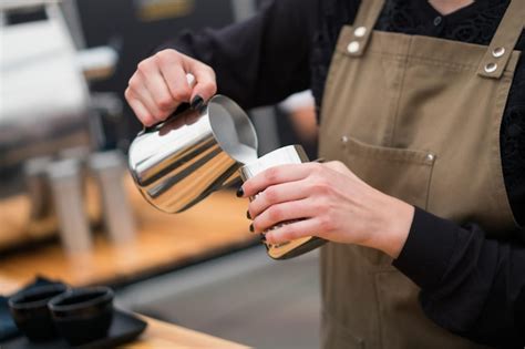 Premium Photo Barista Pours Milk Into A Cup