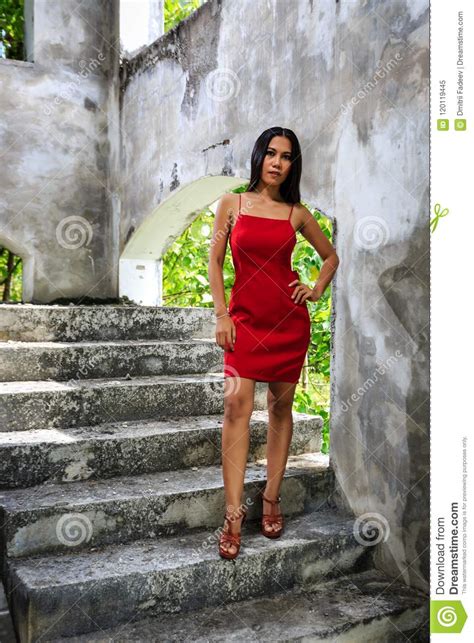 Muchacha Hermosa En El Vestido Rojo Que Presenta En Las Escaleras