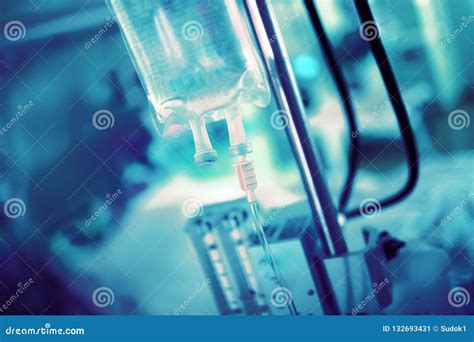 IV Drip On The Background Of Blurred Hospital Equipment And Patient In