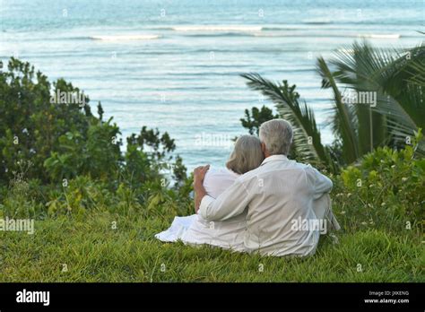 Vieux Couple Assis Sur La Plage Banque De Photographies Et Dimages à