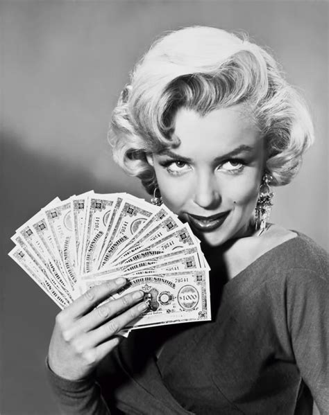 Marilyn Monroe Holding Money In One Hand And Looking At The Camera With