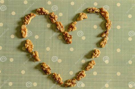 Peeled California Walnut Heart On Blue Background With White Dots Stock