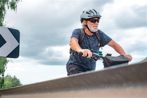 El ciclista senior monta en la carretera en su bicicleta eléctrica