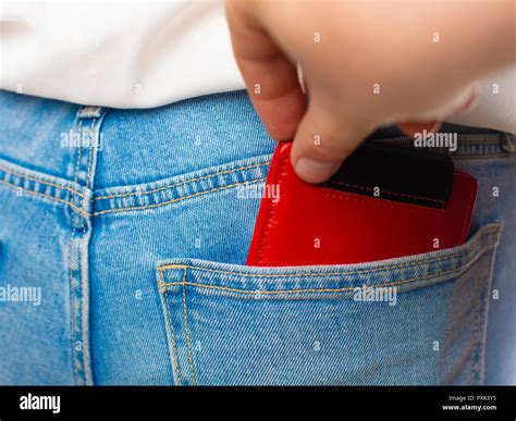 Close Up Of A The Hand Of Thief Stealing The Red Wallet To A Woman