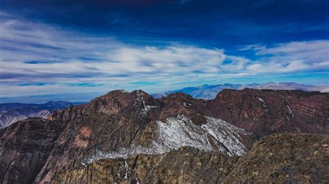 Craggy Mountains Under A Blue Sky With Fluffy Clouds In Toubkal