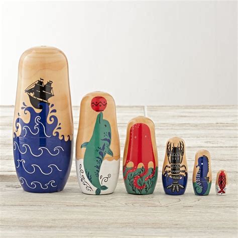 A Group Of Wooden Nesting Dolls Sitting On Top Of A Wooden Table Next