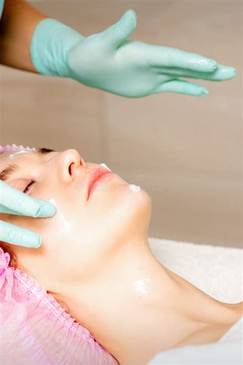 Cosmetologist With Gloved Hands Applies A Moisturizing Mask With