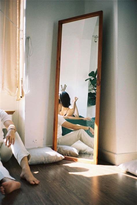 A Woman Sitting On The Floor In Front Of A Mirror