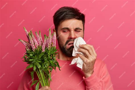 Free Photo Upset Displeased Bearded Man Looks At Plant Which Causes