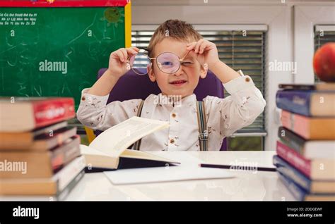 Little boy with glasses reading books Stock Photo - Alamy