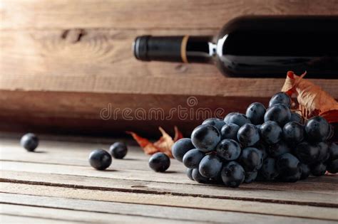 Garrafa De Vinho Tinto E Um Monte De Uvas Sobre Uma Velha Mesa De