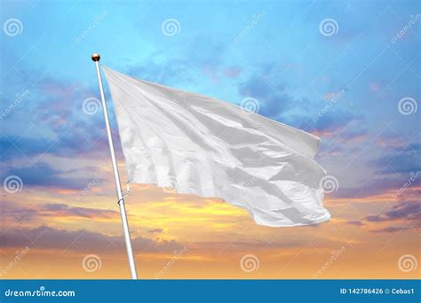 Blank White Flag On Pole Waving In The Wind In The Background Of Sunset