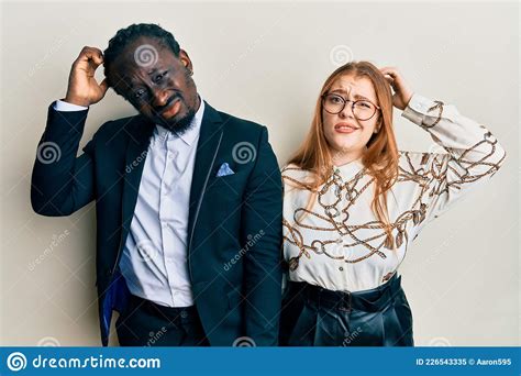 Young Interracial Couple Wearing Business And Elegant Clothes Confuse