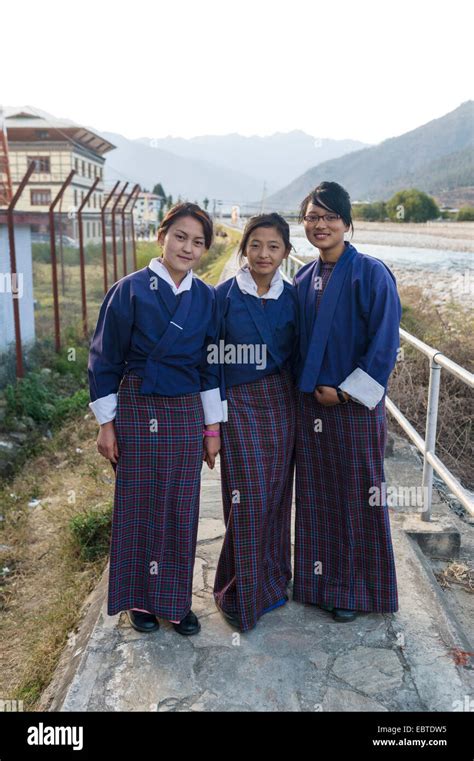 Three secondary school students in uniform at the Paro river bank ...