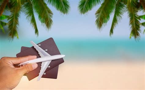 Premium Photo Cropped Hand Holding Passports And Toy Airplane At Beach