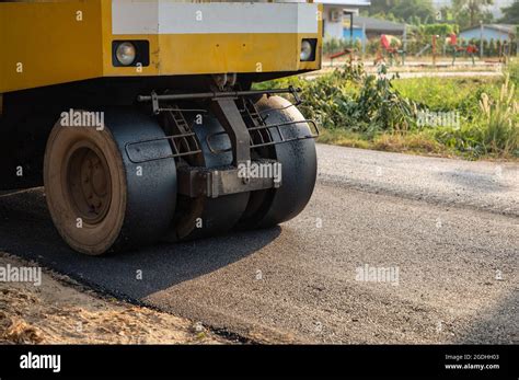 Yellow Steamroller Or Soil Compactor Working On Asphalt Highway Road At