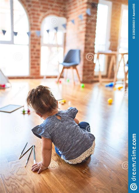 Beautiful Toddler Sitting On The Floor At Kindergarten Stock Image