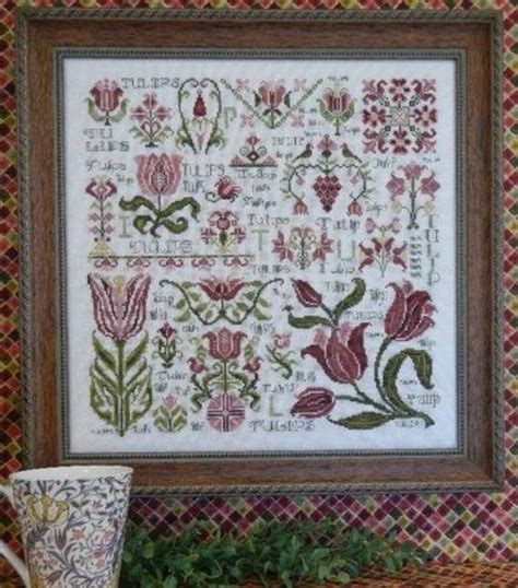 A Cross Stitch Pattern With Flowers And Leaves On The Wall Next To A