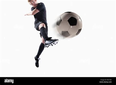 Athlete kicking soccer ball Stock Photo - Alamy