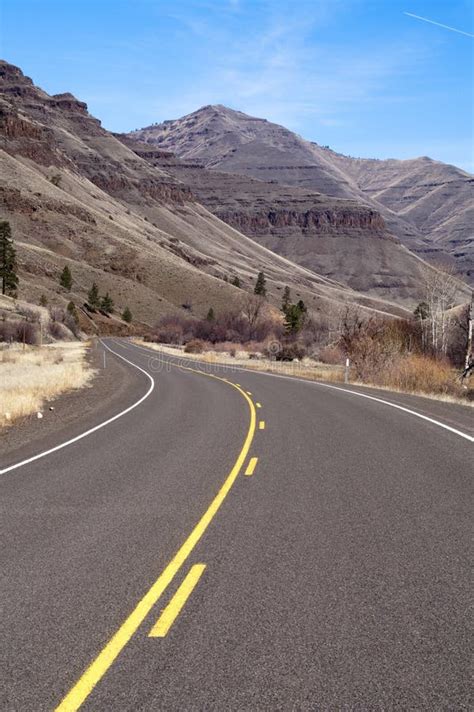 Lonely Two Lane Divided Highway Cuts Through Dry Mountainous Lan Stock