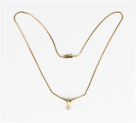 A Gold And Diamond Single Stone Pendant Necklace The Front In A V