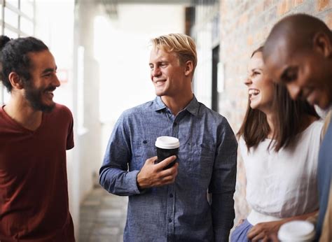 Grupo de sonrisas y amigos en una conversación en el lobby y