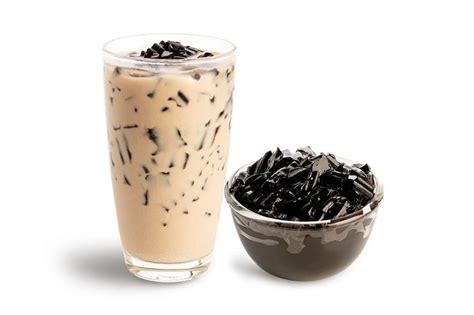 An Iced Drink Next To A Bowl Filled With Black Seed Sprinkles On A