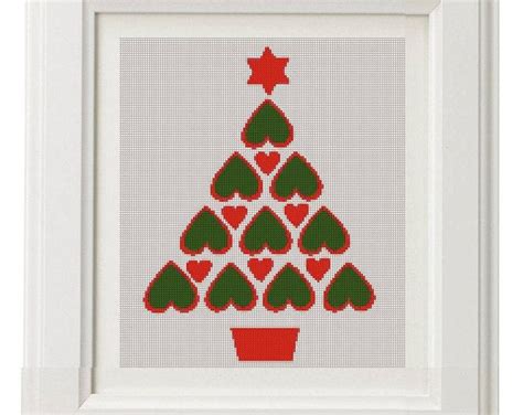 A Cross Stitch Christmas Tree With Hearts In A Red Pot On A White Frame