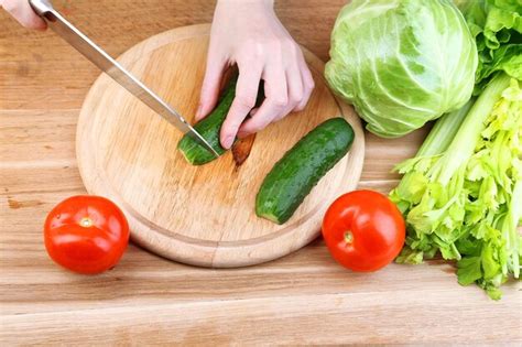 Premium Photo Female Hands Cutting Cucumber On Wooden Board Closeup