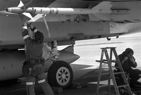 A Ground Crewman Inspects An Aim L Sidewinder Missile Aboard An F