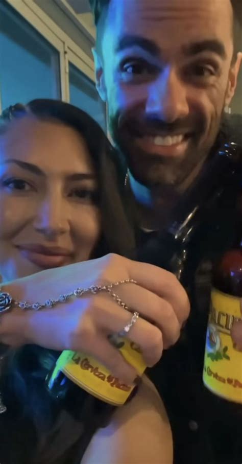 A Man And Woman Posing For A Photo With Some Food