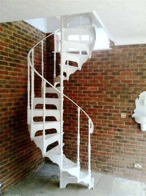 A White Spiral Staircase Against A Brick Wall