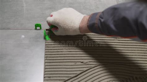 Workers Are Using Plastic Clamps And Wedges To Leveling Ceramic Tile On